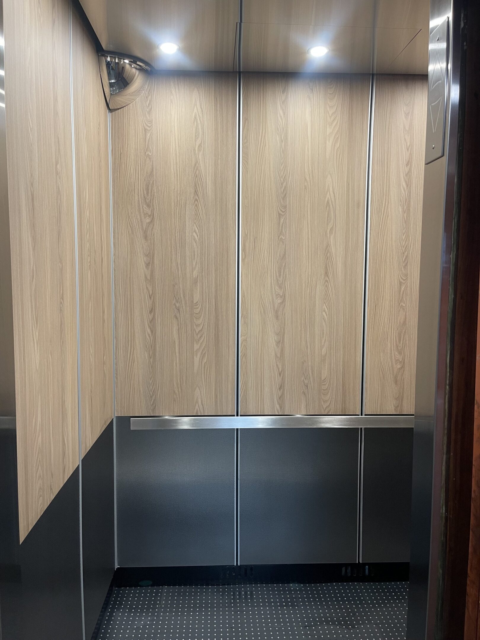 Elevator cab interior featuring velvet-upholstered wall panels by NYC Elevator Cab Co.