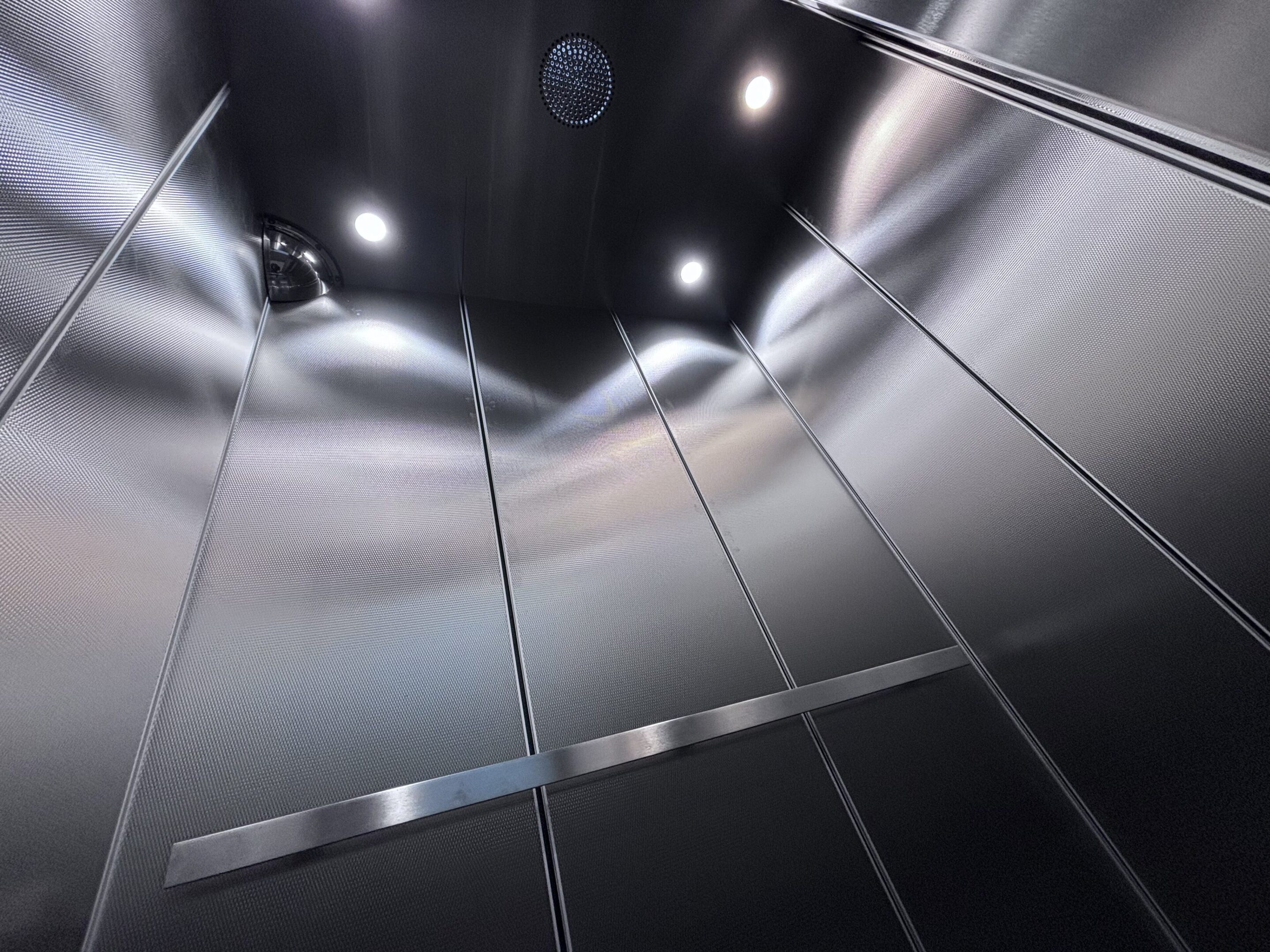 Elevator cab interior featuring satin stainless interior by NYC Elevator Cab Co.