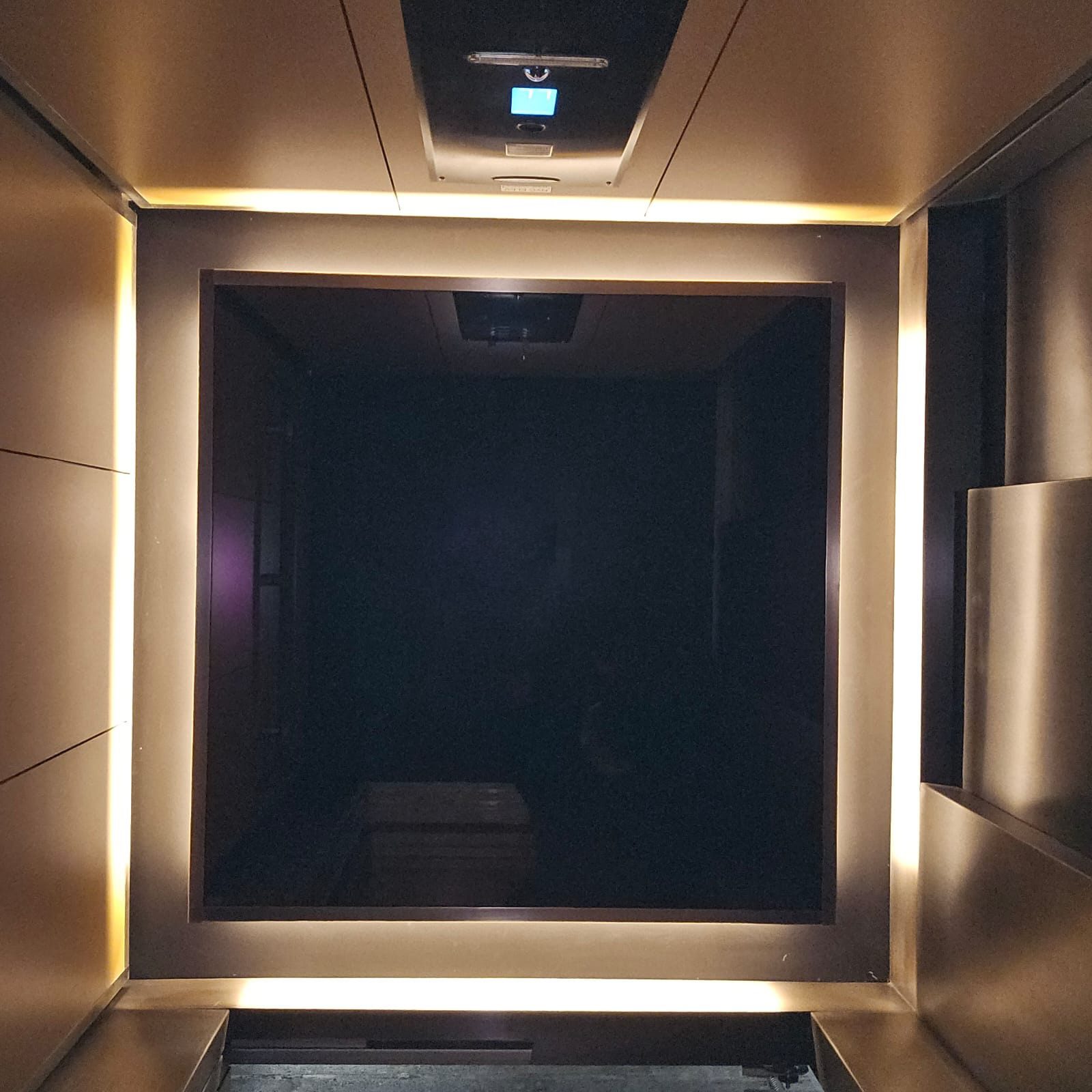 Elevator cab interior featuring bronze & fluted glass panels by NYC Elevator Cab Co.